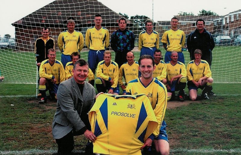 Tony Marler presenting a yellow Prosolve-sponsored shirt to Blunham Village FC, with the team lined up in front of a goal